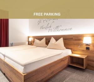 een bed in een kamer met een bordje met de tekst gratis parkeren intelligent malham bij Hotel Wettiner Hof in Riesa