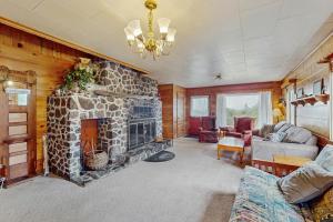 a living room with a stone fireplace in a house at McKinnon's Beach House in Rockaway Beach