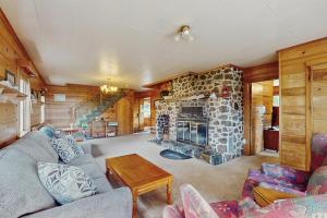a living room with a stone fireplace in a house at McKinnon's Beach House in Rockaway Beach