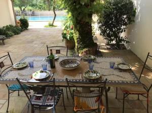 a table and chairs with plates and dishes on it at Vieille House in Saint-Geours-de-Maremne