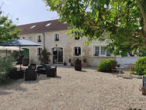 a house with chairs and an umbrella in front of it at Loft in Brizambourg