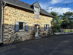 a bike parked outside of a brick house at Beautiful 2-Bedroom Gîte in Montenay in Montenay