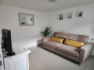 a living room with a couch and a tv at Beautiful 2-Bedroom Gîte in Montenay in Montenay