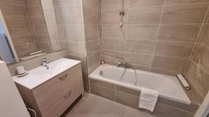 a bathroom with a bath tub and a sink and a bath tub at Résidence-Chalet de Prestige Aspen Park - 106 in Saint-Étienne-de-Tinée
