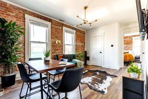 a living room with a brick wall and a table and chairs at Short North Convention Private Parking Pets! in Columbus