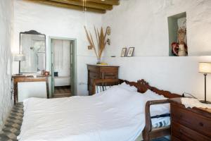 a bedroom with a bed and a dresser and a mirror at Traditional Hora House Serifos in Serifos Chora