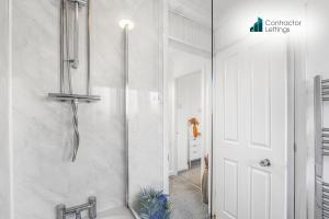 Un baño blanco con ducha y lavabo. en 4 Bedroom Elegant House Near Peterborough City Center with Free Parking - Angus Suites by Contractor Lettings, en Peterborough 72 fotos más