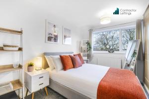 Un dormitorio con una cama blanca y una ventana. en 4 Bedroom Elegant House Near Peterborough City Center with Free Parking - Angus Suites by Contractor Lettings, en Peterborough