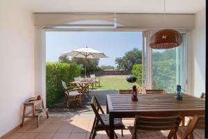 een eetkamer met een tafel en een paraplu bij Casa do Ouriço - Cabanas Tavira in Tavira