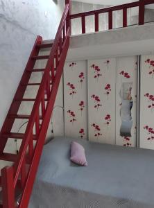 a bedroom with a bunk bed and a red staircase at Chambres d'hôtes - Les Orchidées in Perpignan