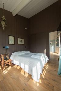a large white bed in a bedroom with wooden floors at Villa Lolita au Cap Ferret à 2 pas du quartier ostréicole in Cap-Ferret +45 photos