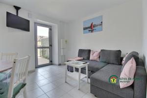 a living room with a couch and a table at Les orchidees in Séné