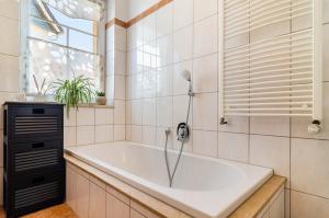 a bath tub in a bathroom with a window at Ferienwohnung Theo  +31 photos