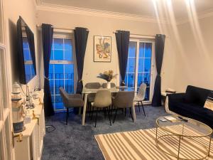 ein Wohnzimmer mit Tisch und Stühlen in der Unterkunft Seaside Escape in Thorpe Bay