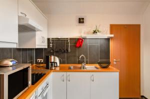 une cuisine avec des armoires blanches et un évier dans l'établissement Swaalvkenüst, à Moormerland