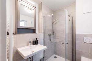 a white bathroom with a sink and a shower at Koblenzer Auszeit in Koblenz +19 photos