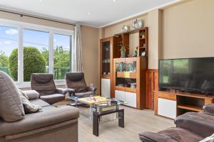 a living room with a flat screen tv and furniture at Casa La Manzana in Villaviciosa