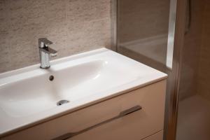 lavabo blanco en el baño junto a una ducha en La Balena Rosa, en Bagni San Filippo 20 fotos más