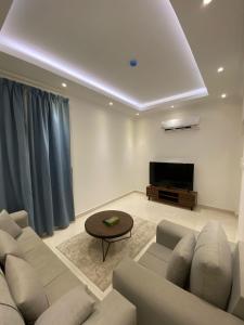 a living room with a couch and a tv at جوهرة الياقوت in Jeddah