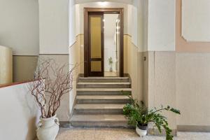 a hallway with stairs and vases with plants at Tiffany - Netflix Disney per 8pp con Garage Box in Trieste