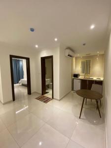 a living room with a table and a kitchen at جوهرة الياقوت in Jeddah