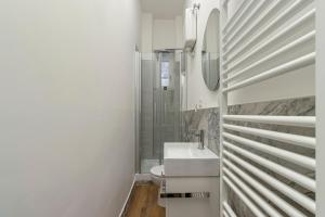 a white bathroom with a sink and a shower at Tiffany - Netflix Disney per 8pp con Garage Box in Trieste