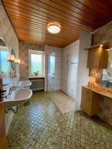 a large bathroom with two sinks and two mirrors at Hesselberg-Oase Ferienhof Hüttner in Röckingen