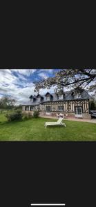 a large house with a white bench in front of it at La Longere du Haras in Manerbe