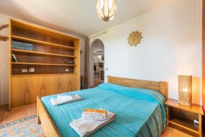 Un dormitorio con una cama con una colcha azul. en Casa Michelle, en Villaputzu