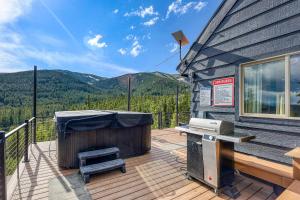 a deck with a hot tub and a grill at Skyline Lodge in Ninetyfour