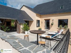 a patio with a table and chairs and a table at Gite Les Albarets in Rieupeyroux