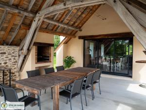 an outdoor dining room with a wooden table and chairs at Gite Les Albarets in Rieupeyroux