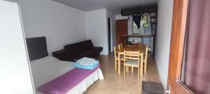 a small room with a bed and a table and chairs at cabañas en cuchilla alta in Cuchilla Alta