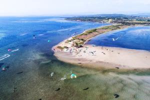 Una vista aérea de una playa con gente en el agua. en Su Suergiu, en San Giovanni Suergiu