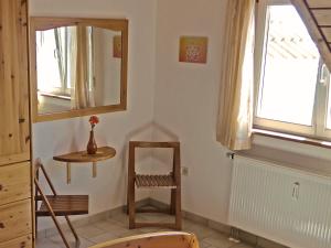 une pièce avec un miroir, une chaise et une table dans l'établissement Haus Sonntag, à Frickingen 16 autres photos