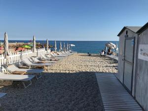 ヴァリゴッティにある11 Mehariの浜辺のラウンジチェアとパラソル