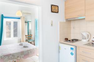 Una pequeña cocina con una mesa y una ventana. en The Castle House Kea, en Ioulida