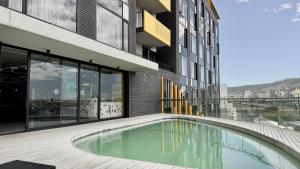 a building with a swimming pool in front of a building at Stylish Cape Town Apartment - Table Mountain View in Cape Town