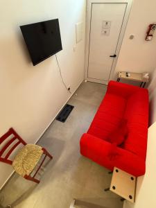 een woonkamer met een rode bank en een stoel bij RED Cabin-Larnaca Centrum in Larnaka