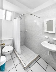 une salle de bain blanche avec toilettes et lavabo dans l'établissement Casa Chinelo Alberca Wifi cerca hospital ISSSTE UTEZ DIEZ, à Temixco