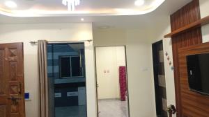 Pawan villa cottage في بانتشجانى: حمام بباب زجاجي ومرآة