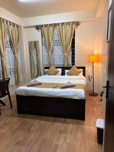 a bedroom with a large bed in front of windows at The urban rest in Shillong