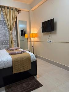 a bedroom with a bed and a flat screen tv at The urban rest in Shillong