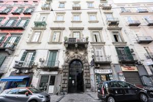 a large white building with cars parked in front of it at Maison Noir Napoli in Naples