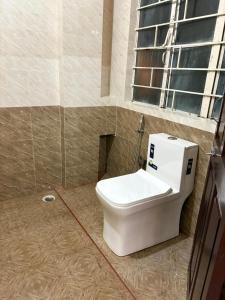 a toilet in a bathroom with a window at The urban rest in Shillong