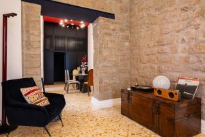 a living room with a black chair and a brick wall at Maison Noir Napoli in Naples
