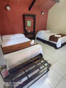 two beds in a room with red walls at Bosques del Tibet in Cerro Verde +127 photos