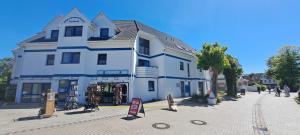 a large white building on the side of a street at Neptuns Oase in Zingst