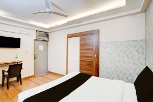 a bedroom with a bed and a desk and a television at Hotel O Knights Inn in Ghaziabad +21 photos