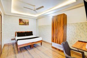 a bedroom with a bed and a wooden cabinet at Hotel O Knights Inn in Ghaziabad
